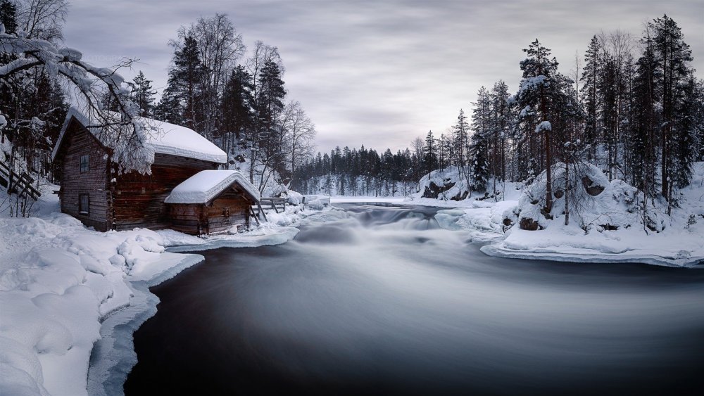 Дом в лесу у реки зимой