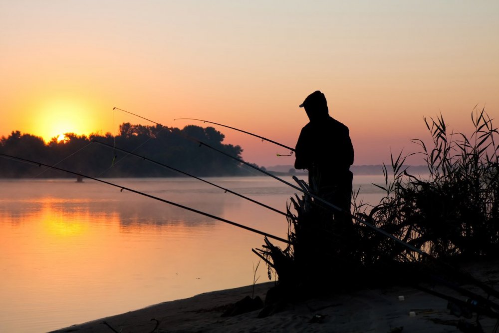 Силуэт рыбака на закате