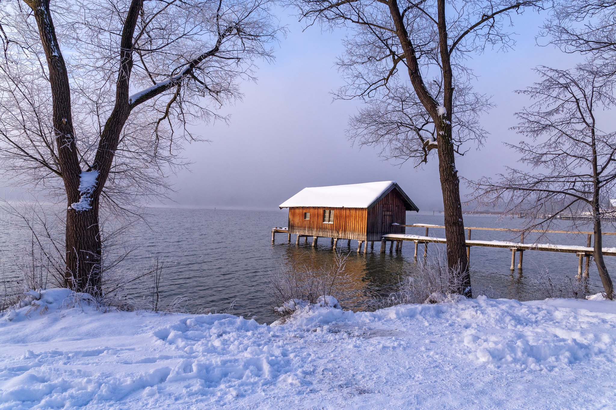 Берег озера зимой. Аммерзее Бавария. Озеро Аммерзе. Озеро Аммерзее в Баварии. Домик на берегу заснеженного озера.