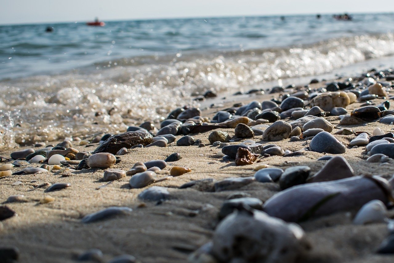 Усеянном гальками. Галечный пляж Анапа камни. Галечный пляж Адлер. Каменистый берег в Сочи чёрное море. Анапа каменный берег.