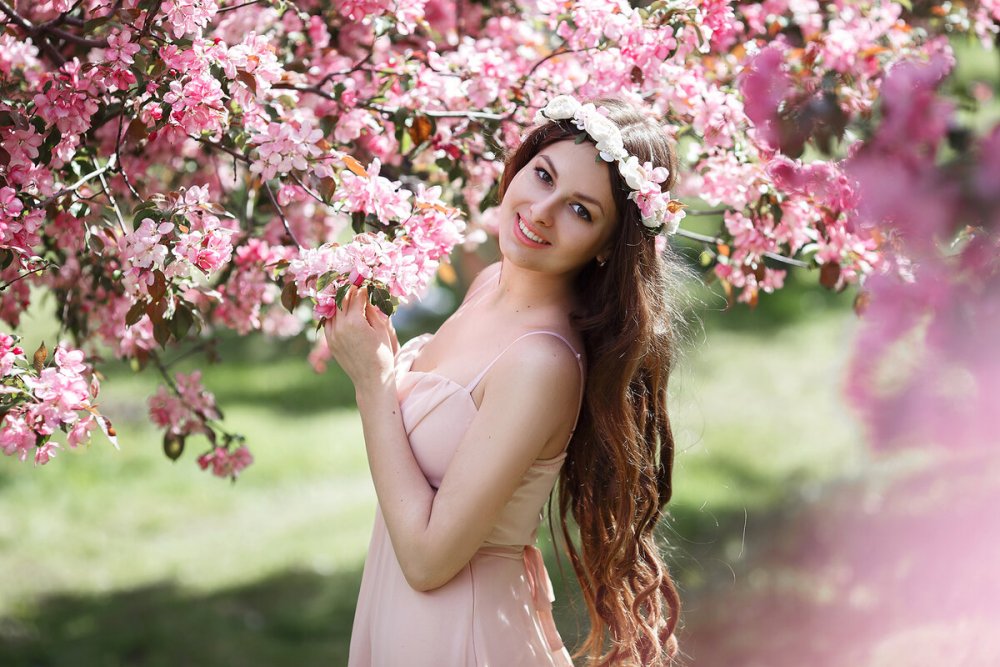 Девушка в цветущем яблоневом саду
